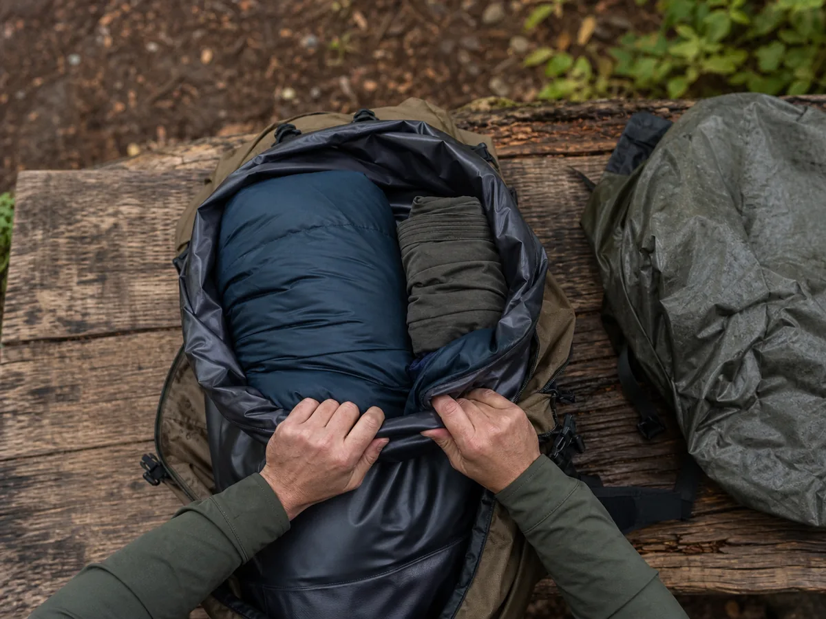 Open backpack with a waterproof liner protecting sleeping insulation and dry camp clothing before heavier gear is loaded - backpack dry core | KnowOutdoor
