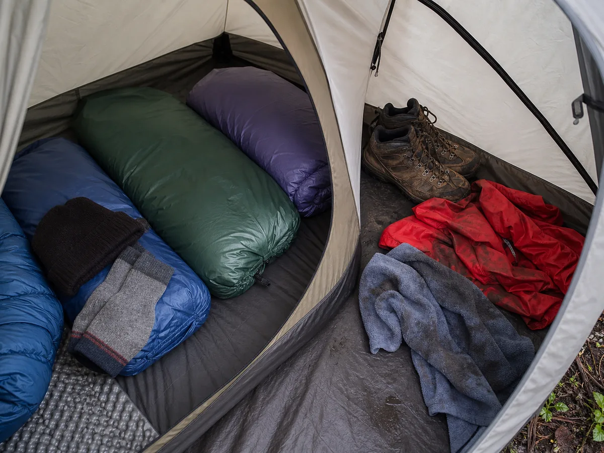 Dry sleeping bags socks and hat separated from wet boots jacket and towel inside a tent - dry camping reserve | KnowOutdoor