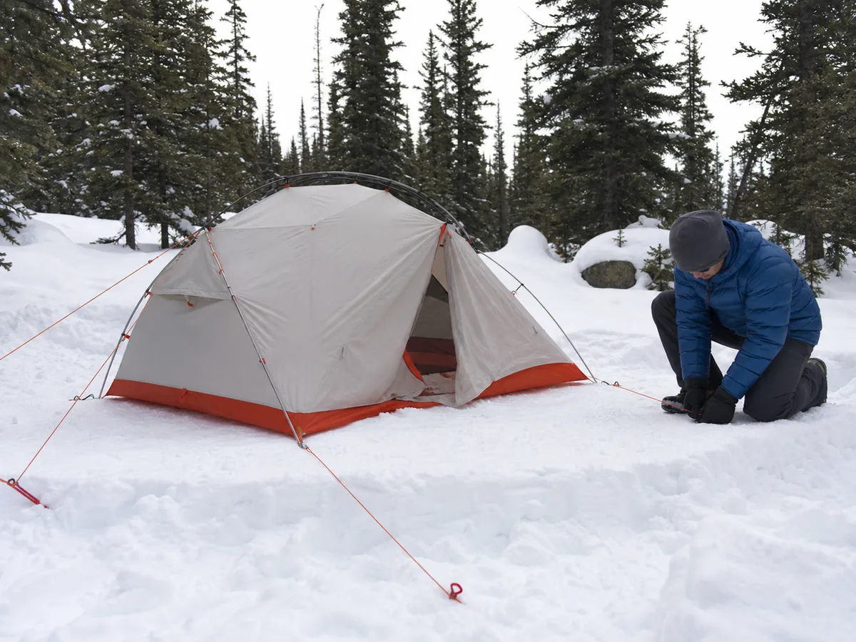 Winter tent on a compacted legal snow platform with secure snow anchors clear ventilation and protected entrance - winter campsite setup | KnowOutdoor