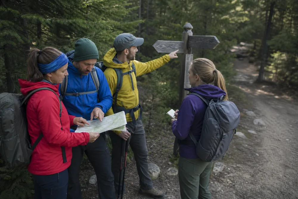 Hiking group marking a signed junction as the meetup point and noting each person's clothing before starting