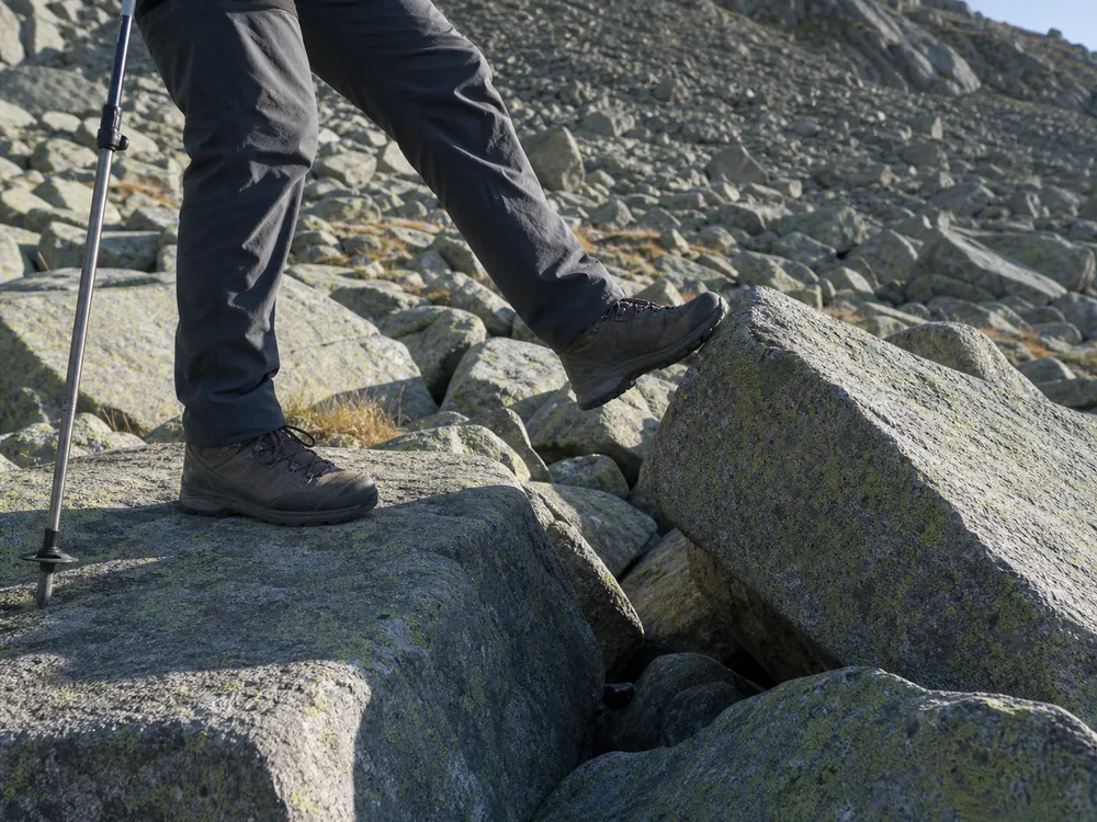 Hiker testing a broad talus block before transferring body weight